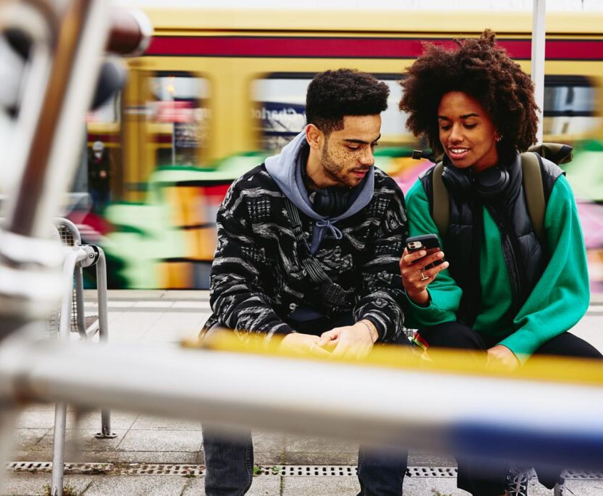 A photo of a man and a woman working remotely by the train platform