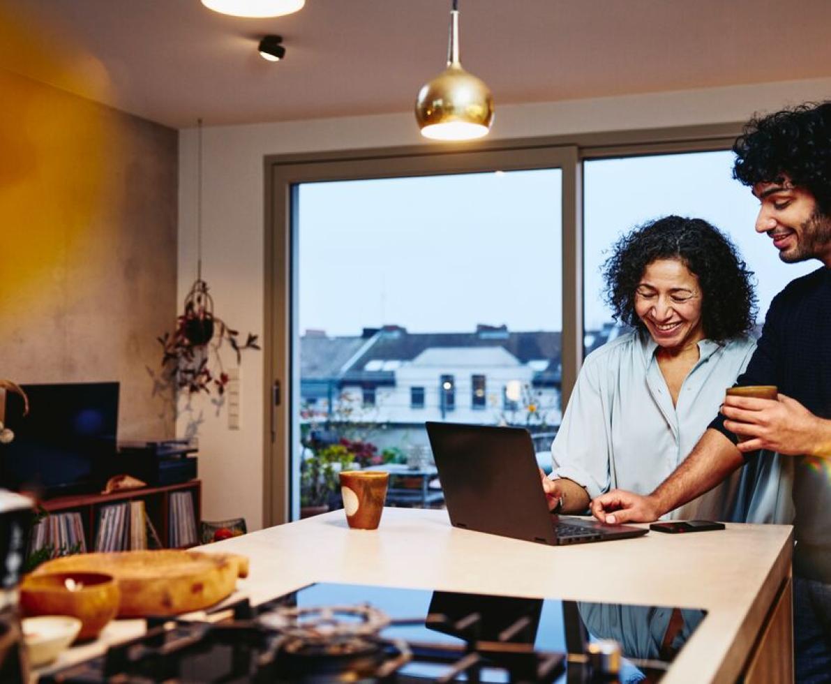 man and woman smiling looking at the computer