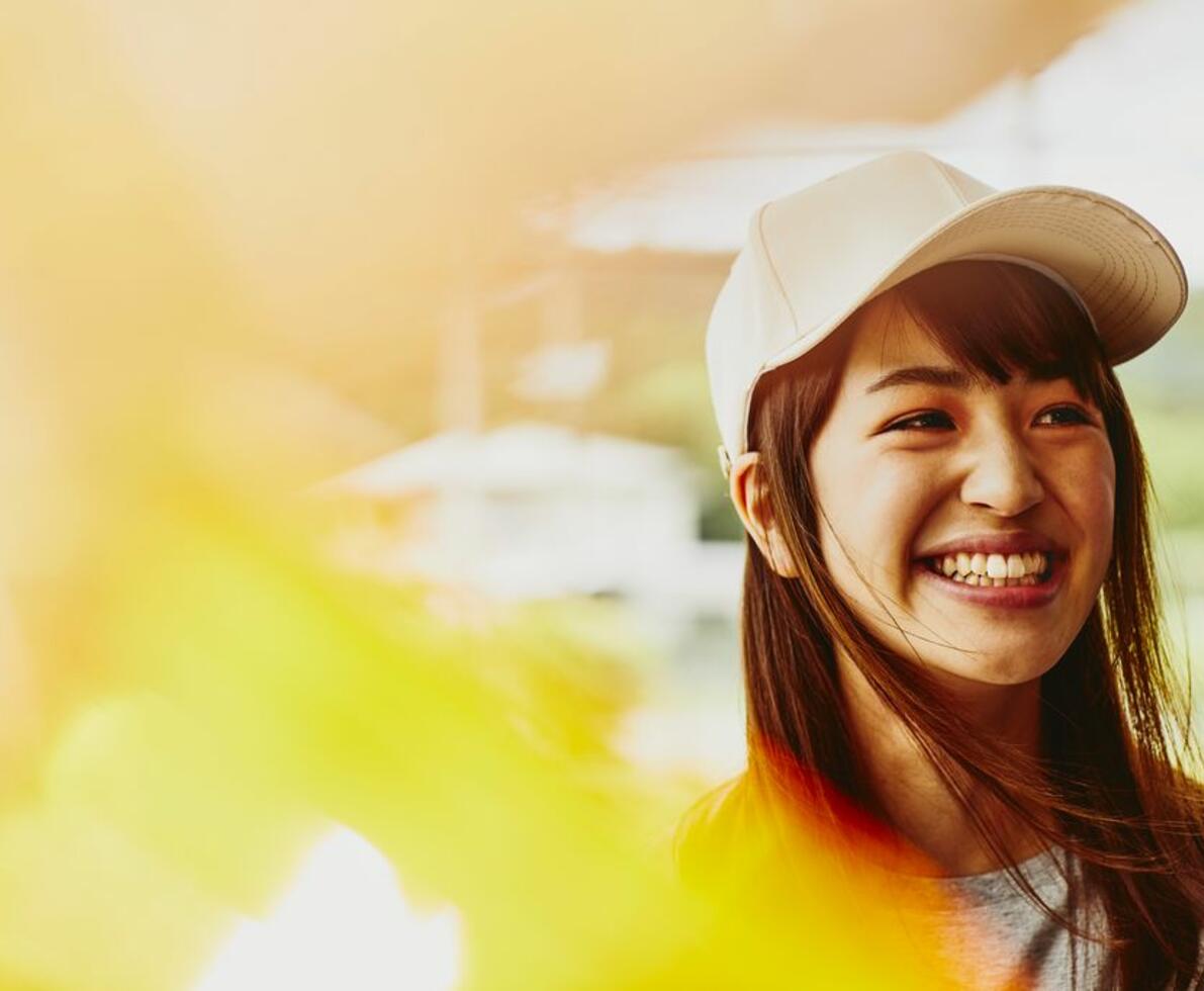 Smiling woman wearing a white cap looking at the far right