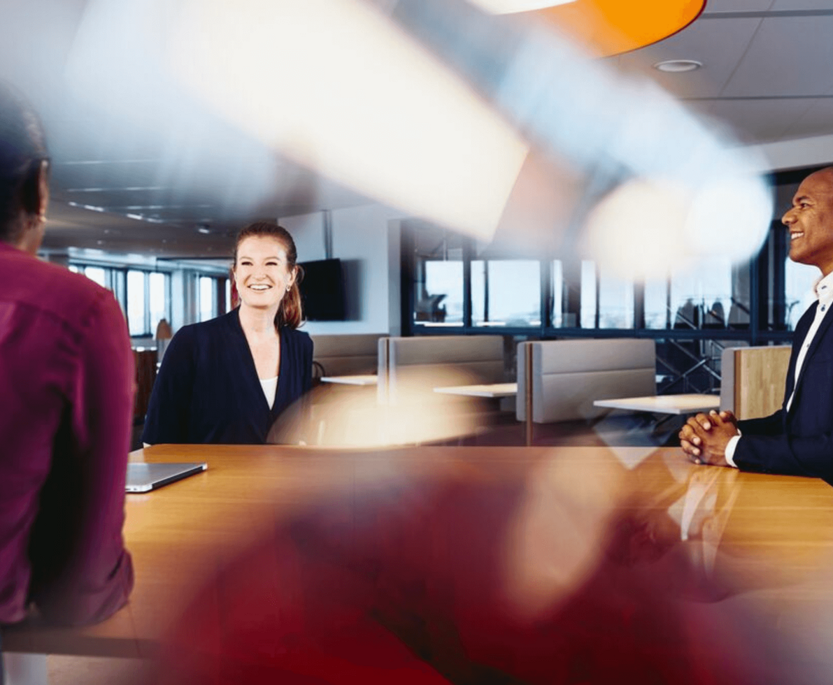 three coworkers in business attires having a meeting