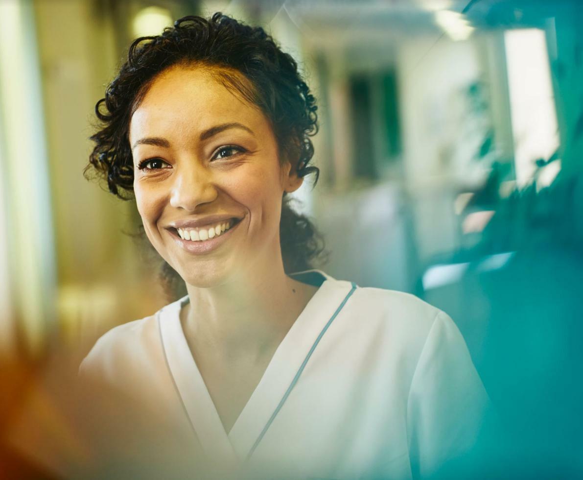 a woman in a white nursing attire smiling