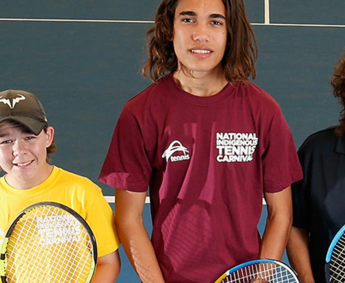 4 people of different ages and backgrounds standing with tennis rackets on a tennis court