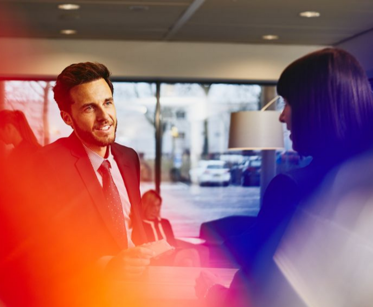 two people in an office setting having a conversation two people in an office setting having a conversation