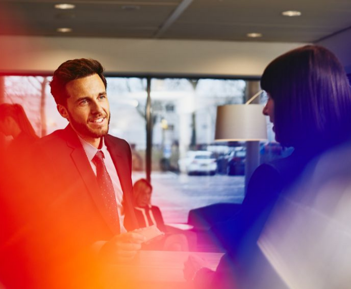 two people in an office setting having a conversation