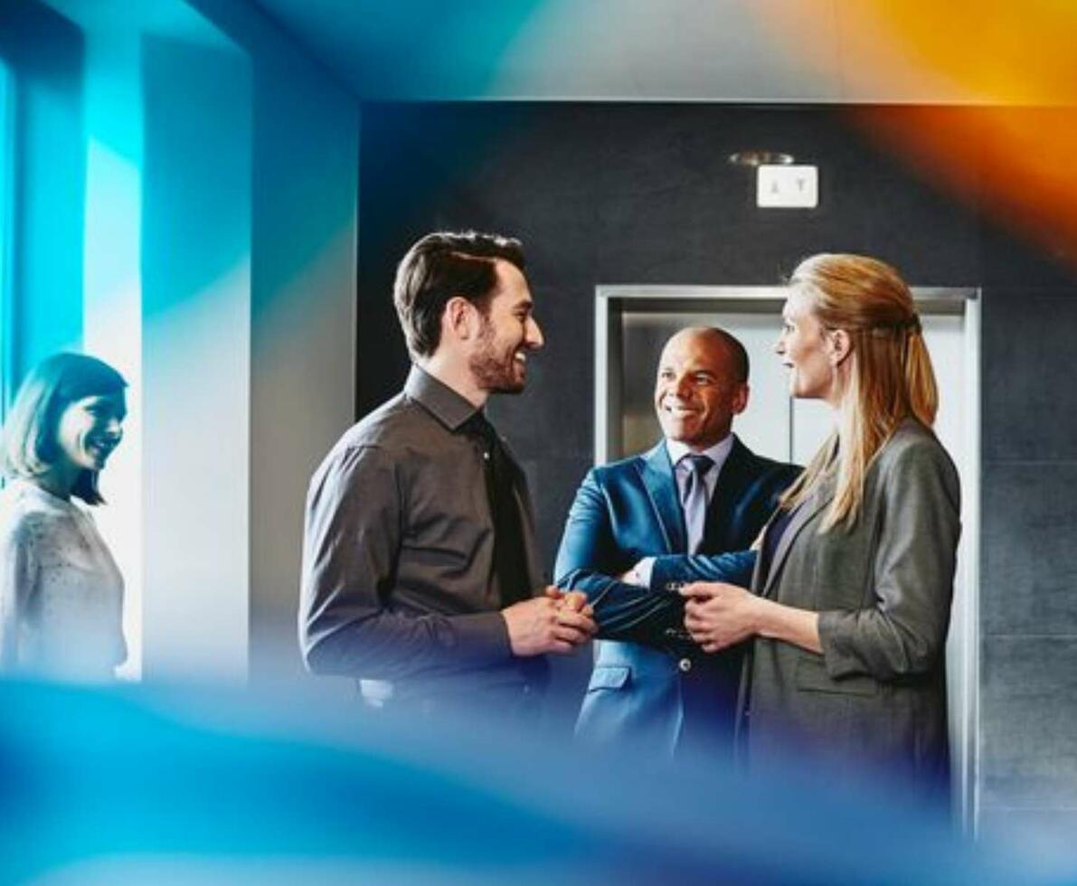 group of colleagues in suits talking in the office