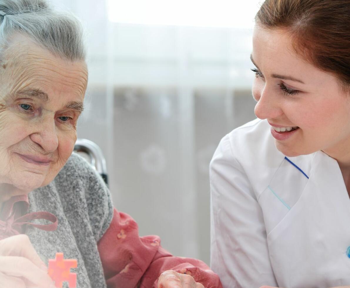 aged care nurse sitting with her patient who is doing a jigsaw aged care nurse sitting with her patient who is doing a jigsaw