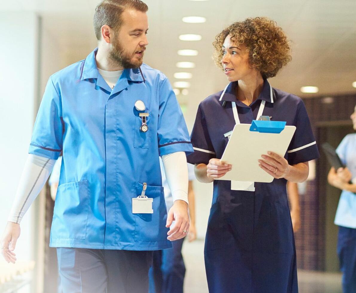 two healthcare professionals having a conversation in a hospital setting