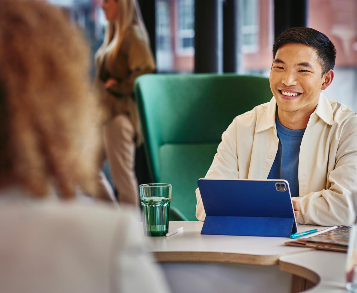 an image of a man talking to a woman with a tablet in front of him