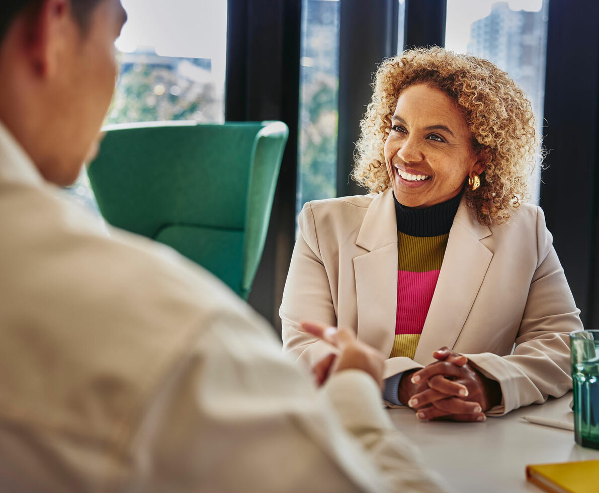 an image of a man talking with a woman while seated in front of her