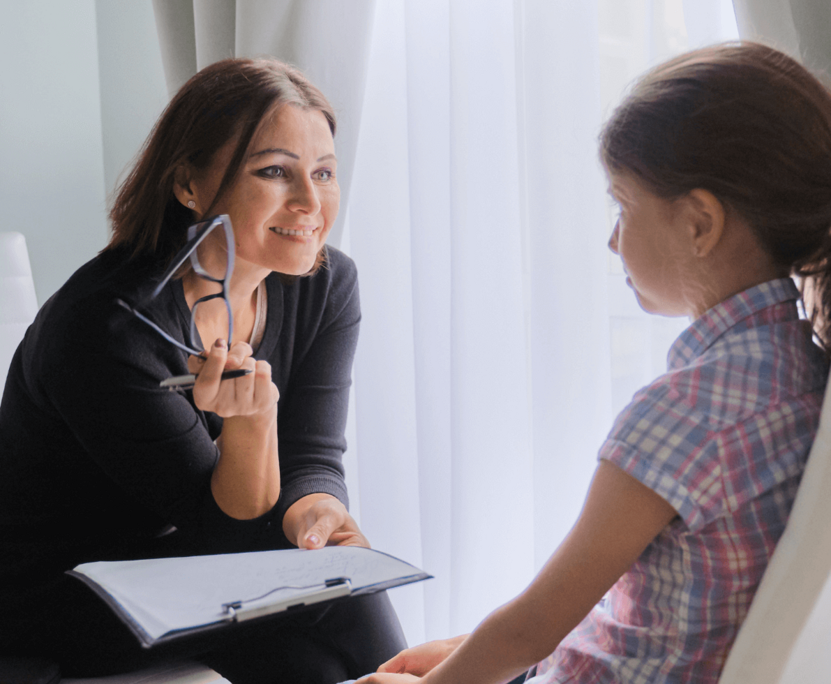 a woman talking to a child while holding a clipboard