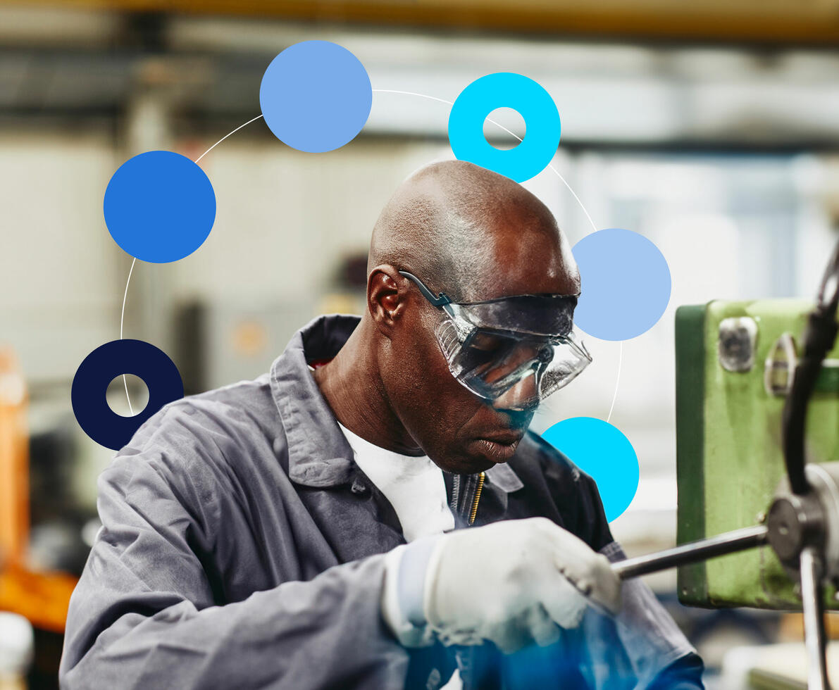 an image of a man wearing safety googles and gloves working on a machine