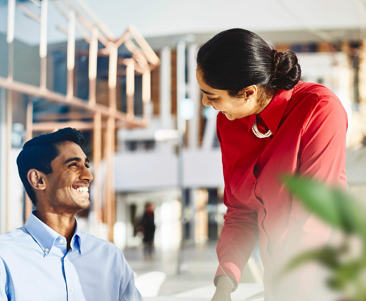 an image of two coworkers smiling and talking to each other