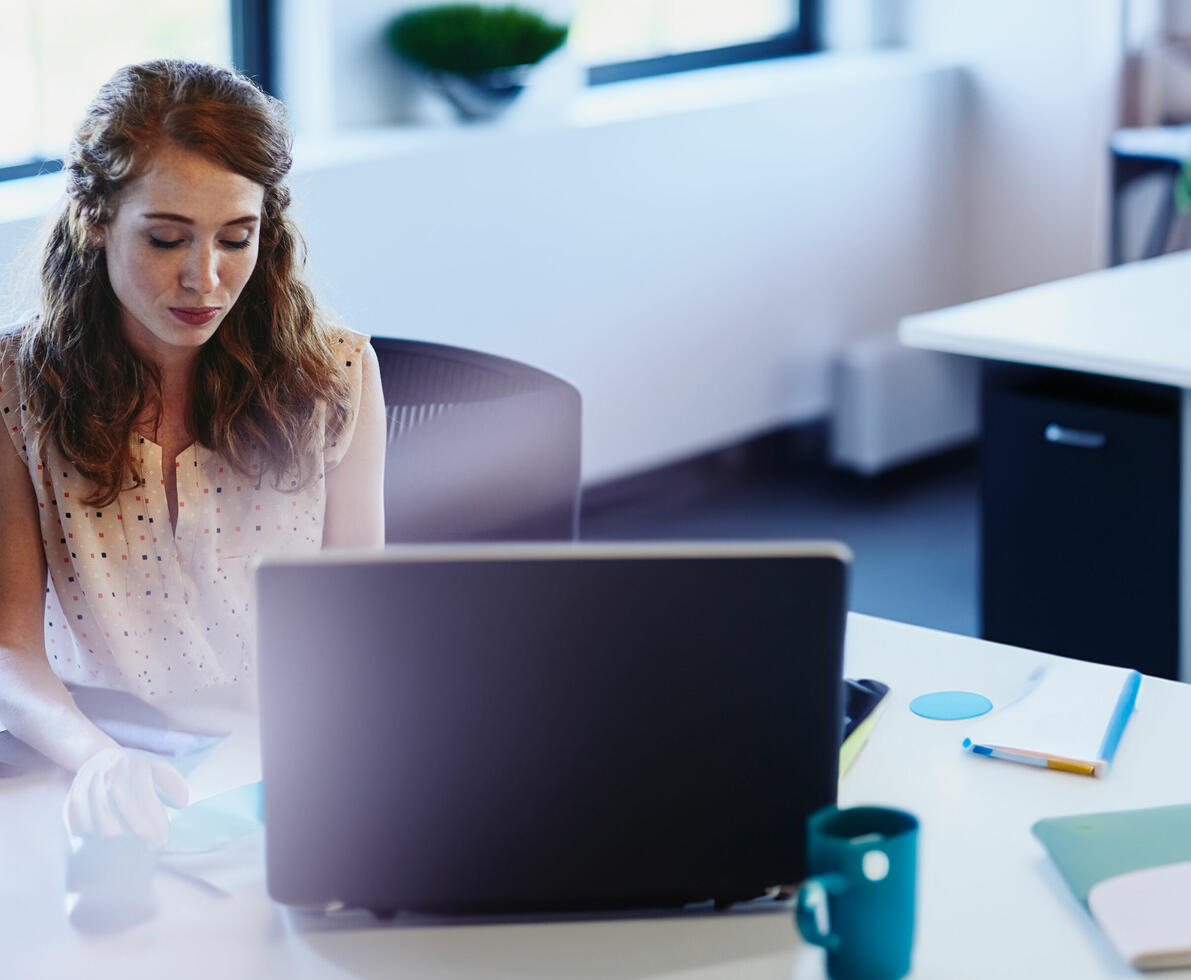 woman sitting at a desk behind a laptop