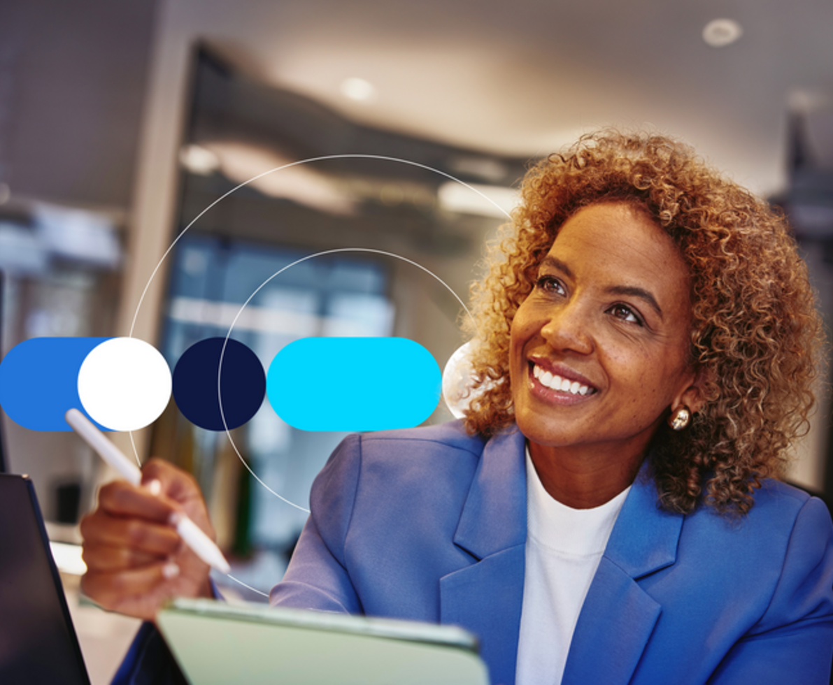 woman in blue blaser holding a pen and paper pad, sitting at a desk with blue icon