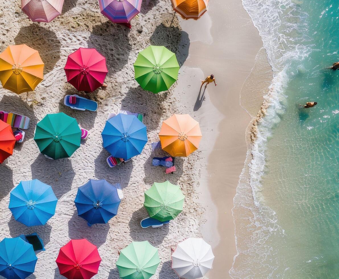 image depicting a beach with many colourful umbrellas on the sand and people walking in the water at the beachfront