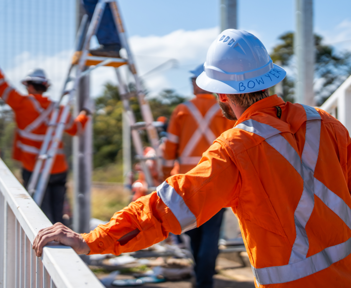 an image of a man wearing a hardhat and looking at his other maintenance coworkers