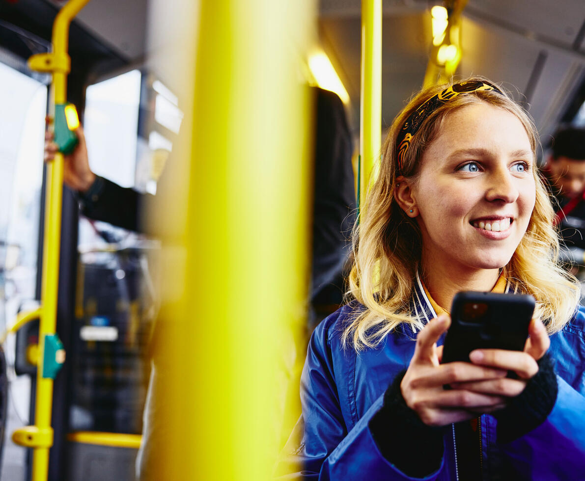 person on phone sitting in the bus