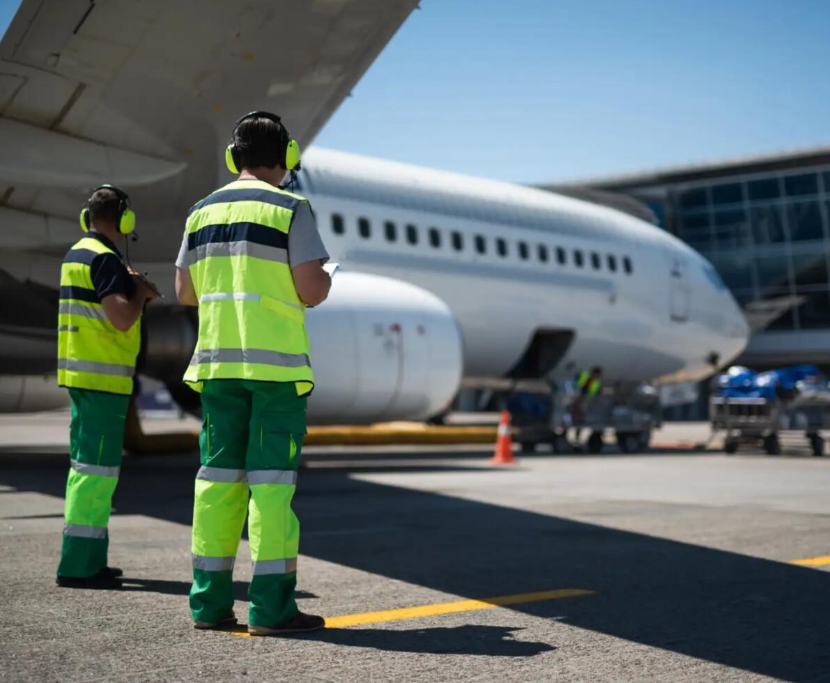 an image of two men looking at a plane