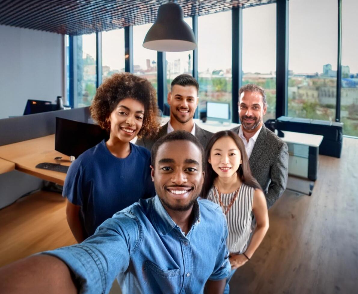 an image of coworkers smiling and posing for the camera in a casual office setting