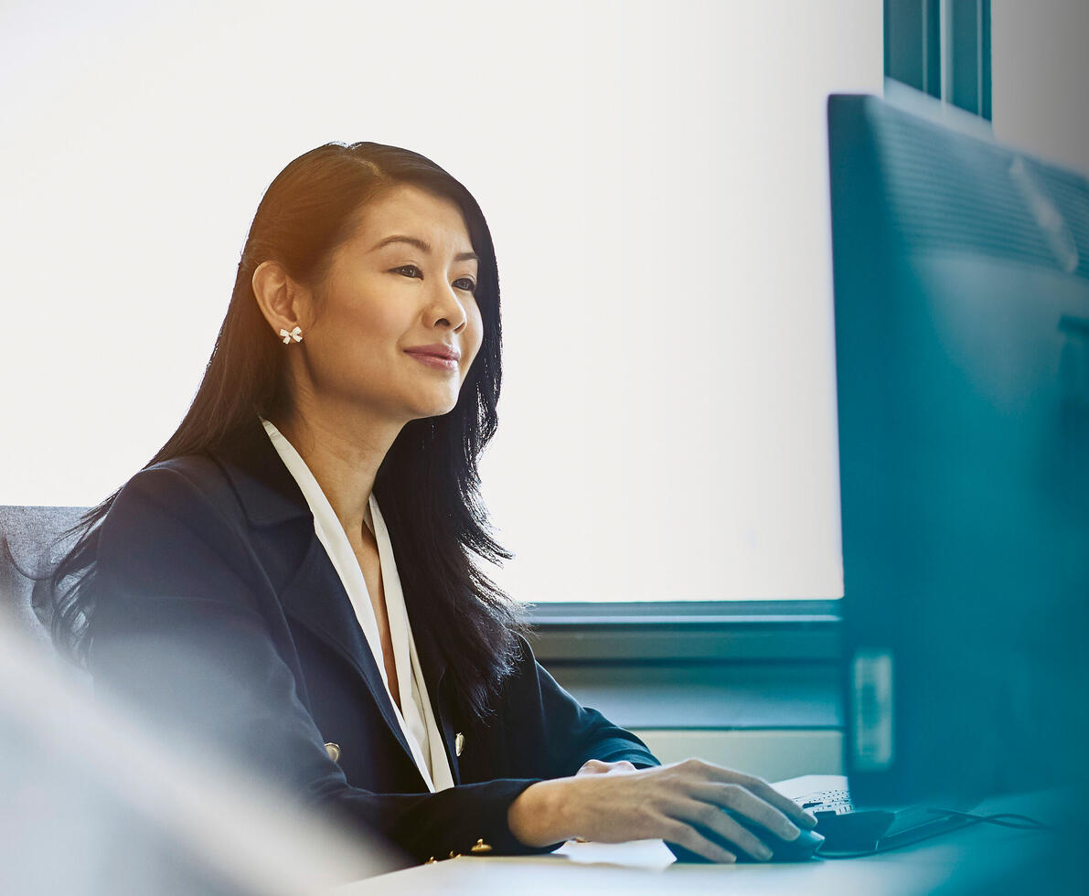 an image of a woman typing on her keyboard while smiling