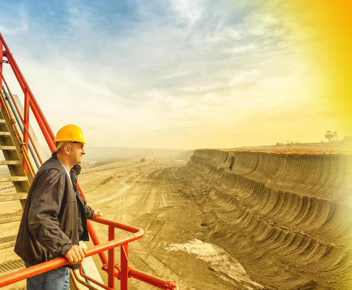 an image of a man wearing a hard hat looking at a plot of land