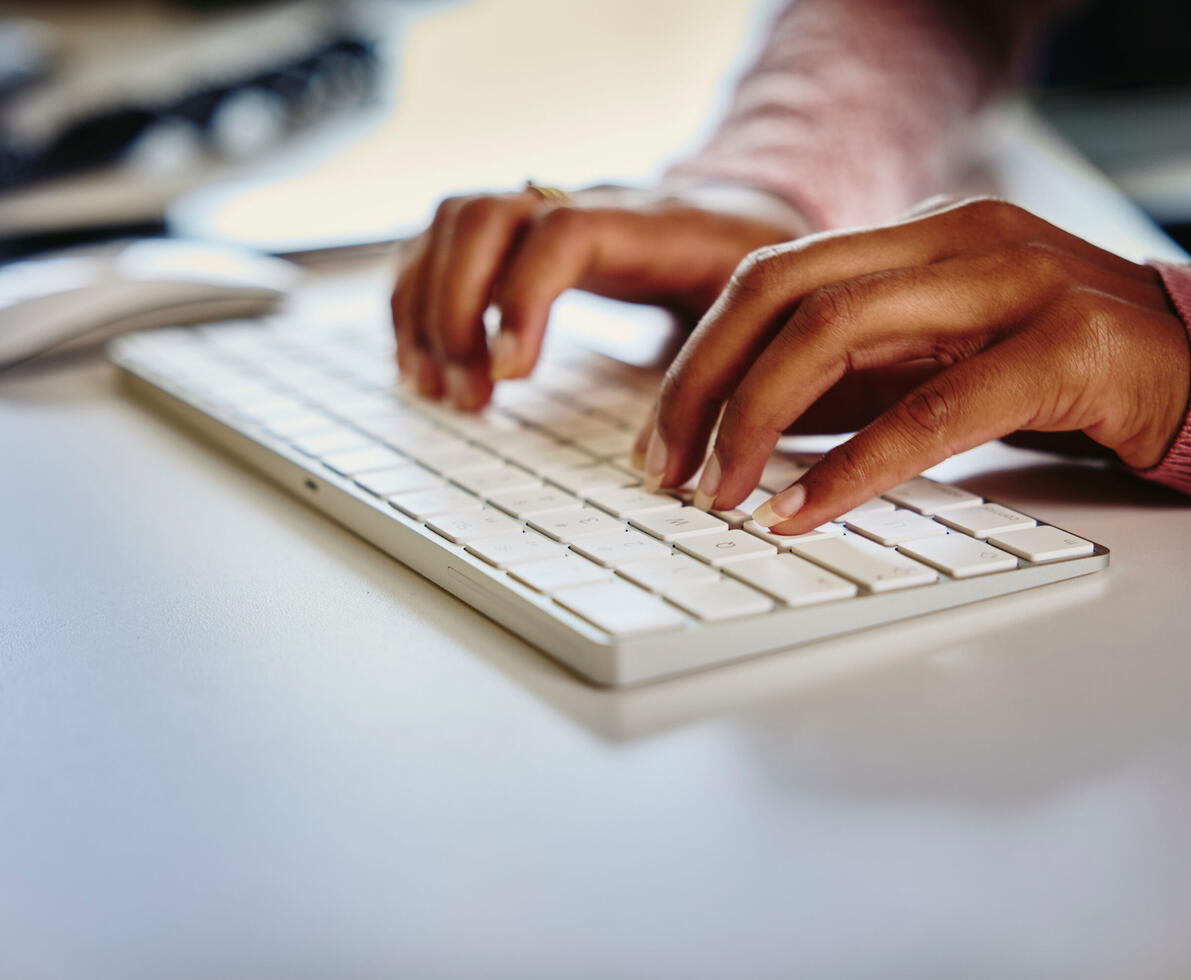 a close up of hands typing on a keyboard