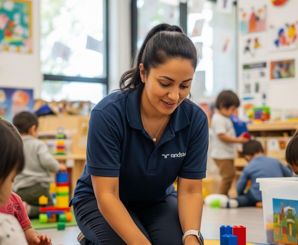early childhood educator in a daycare centre setting surrounded by children