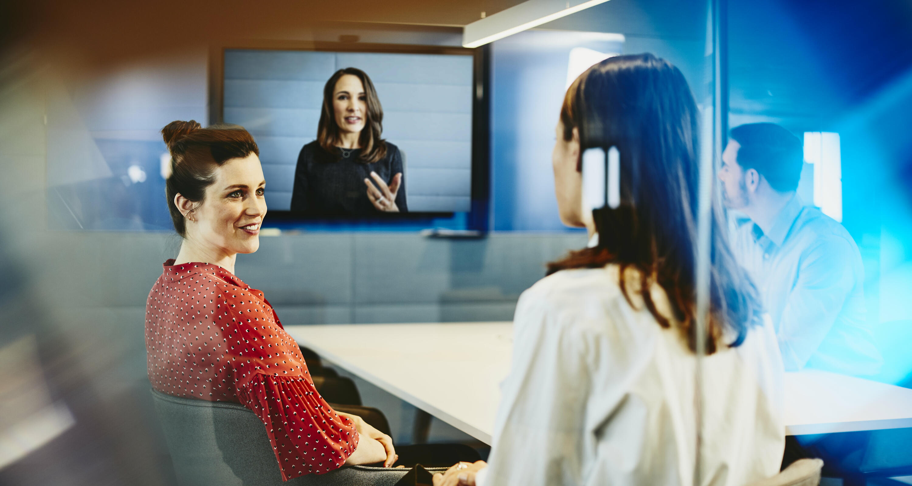 Two business women and a man in an office having a Hangout Two business women and a man in an office having a Hangout
