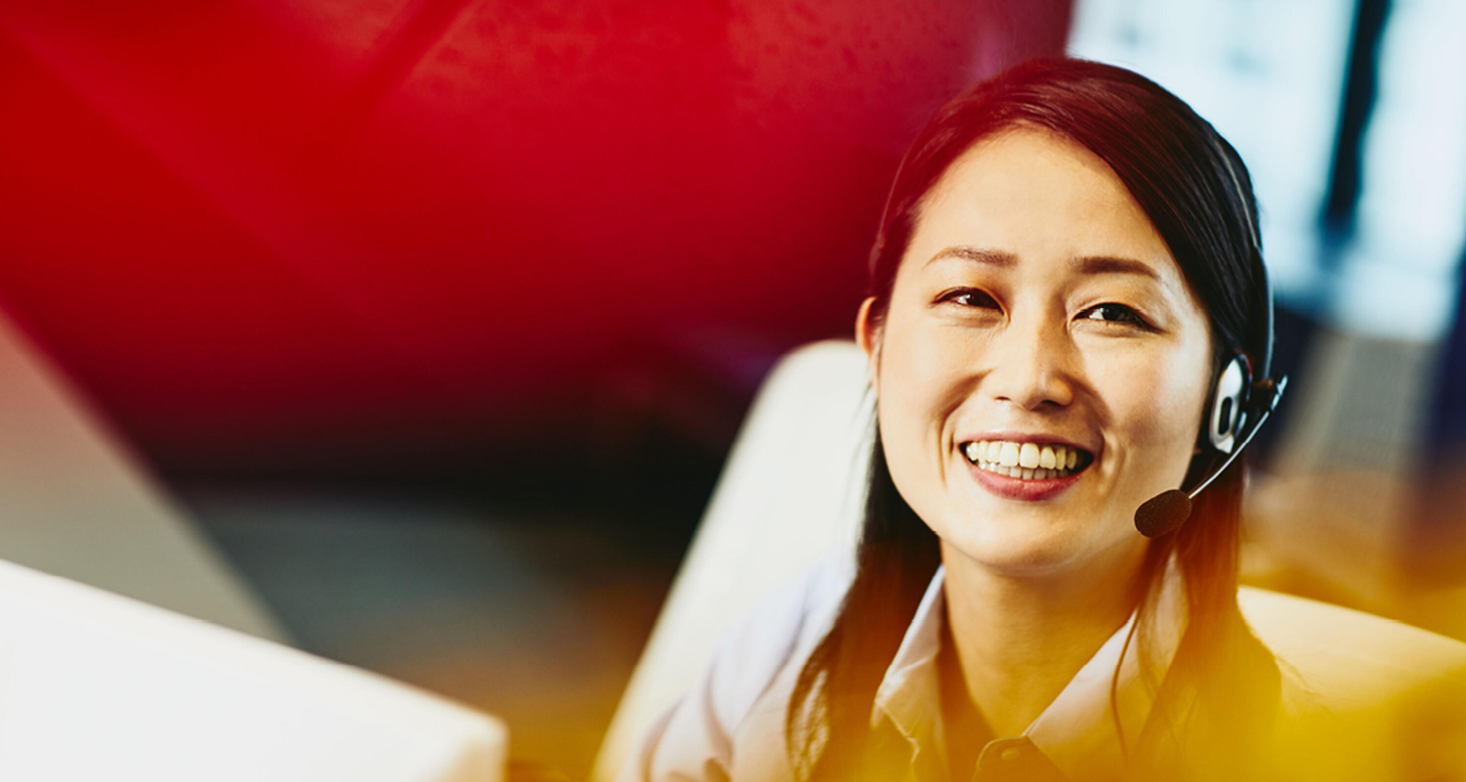 A smiling woman wearing a headset