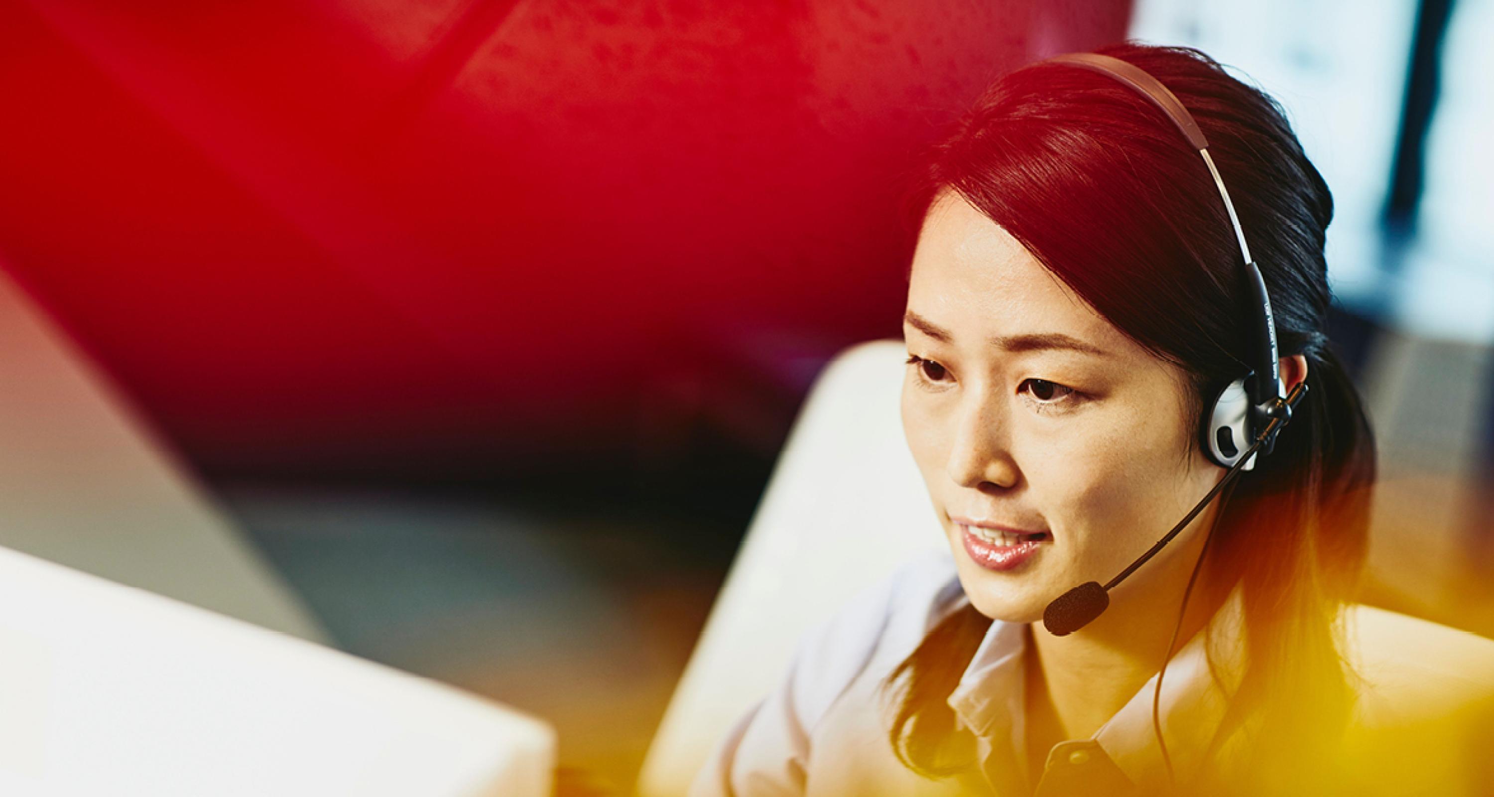 A woman wearing a headset talking to a client