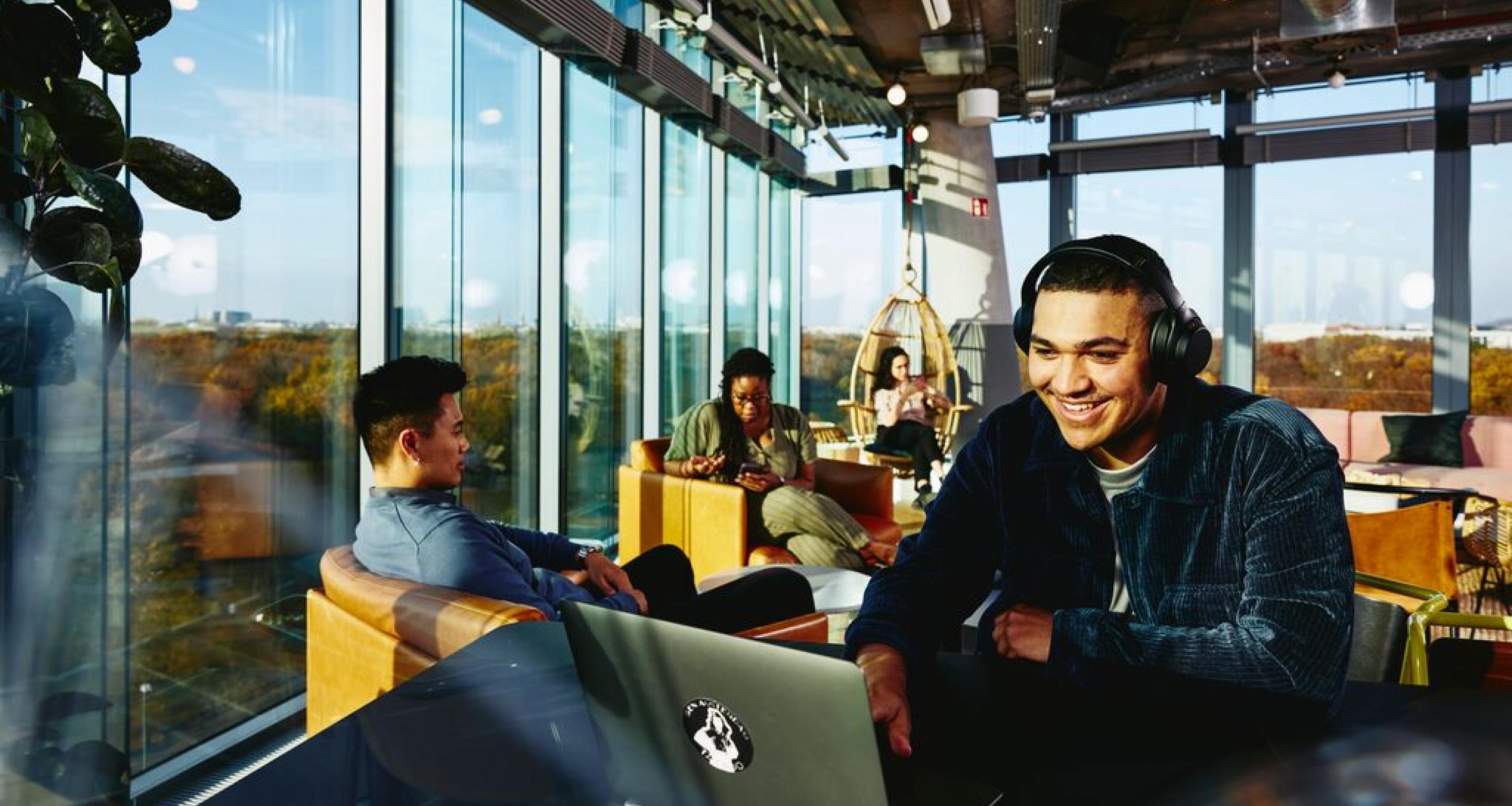 man smiling with headphones and computer