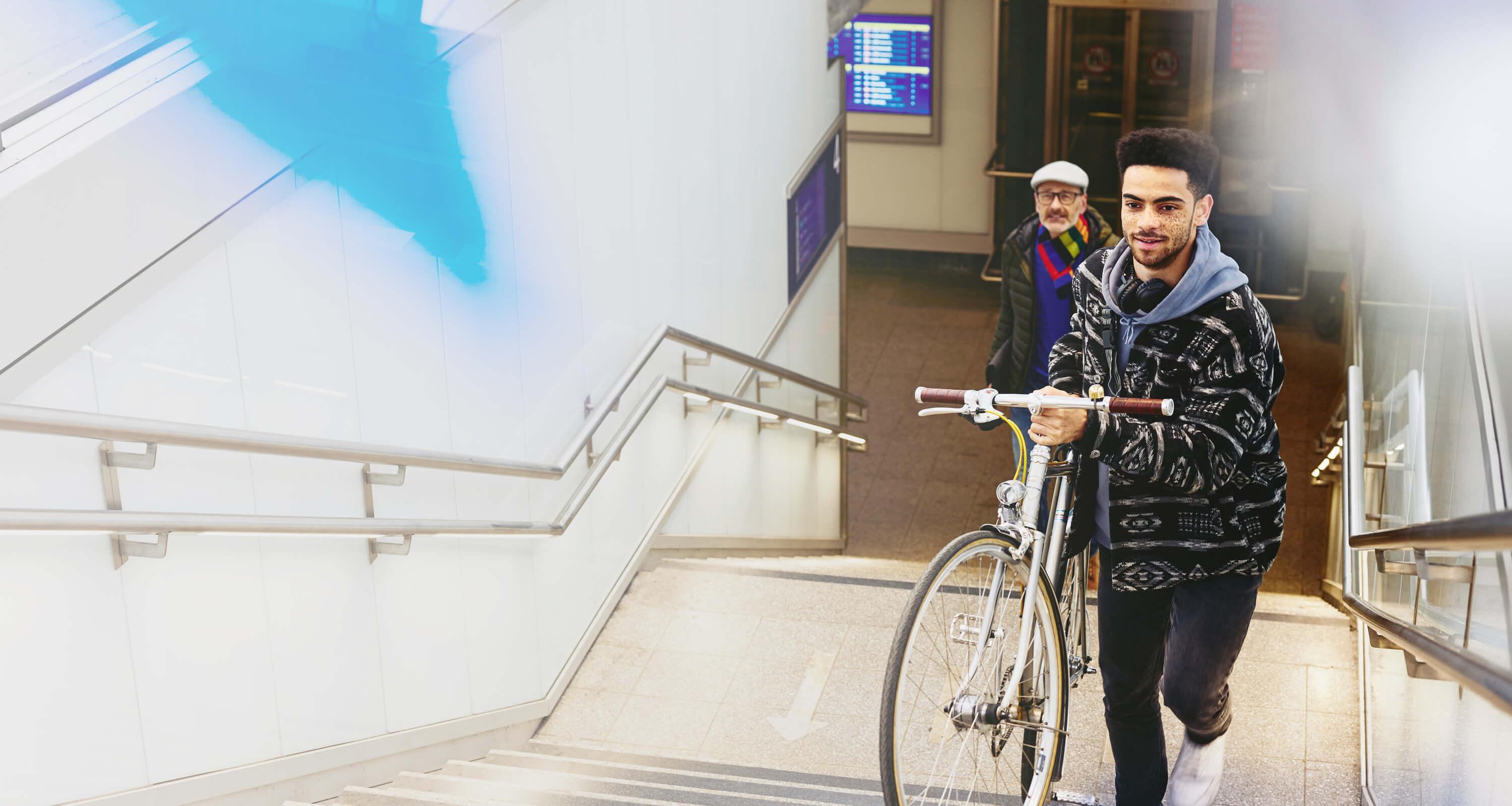 A photo of a man carrying his bike