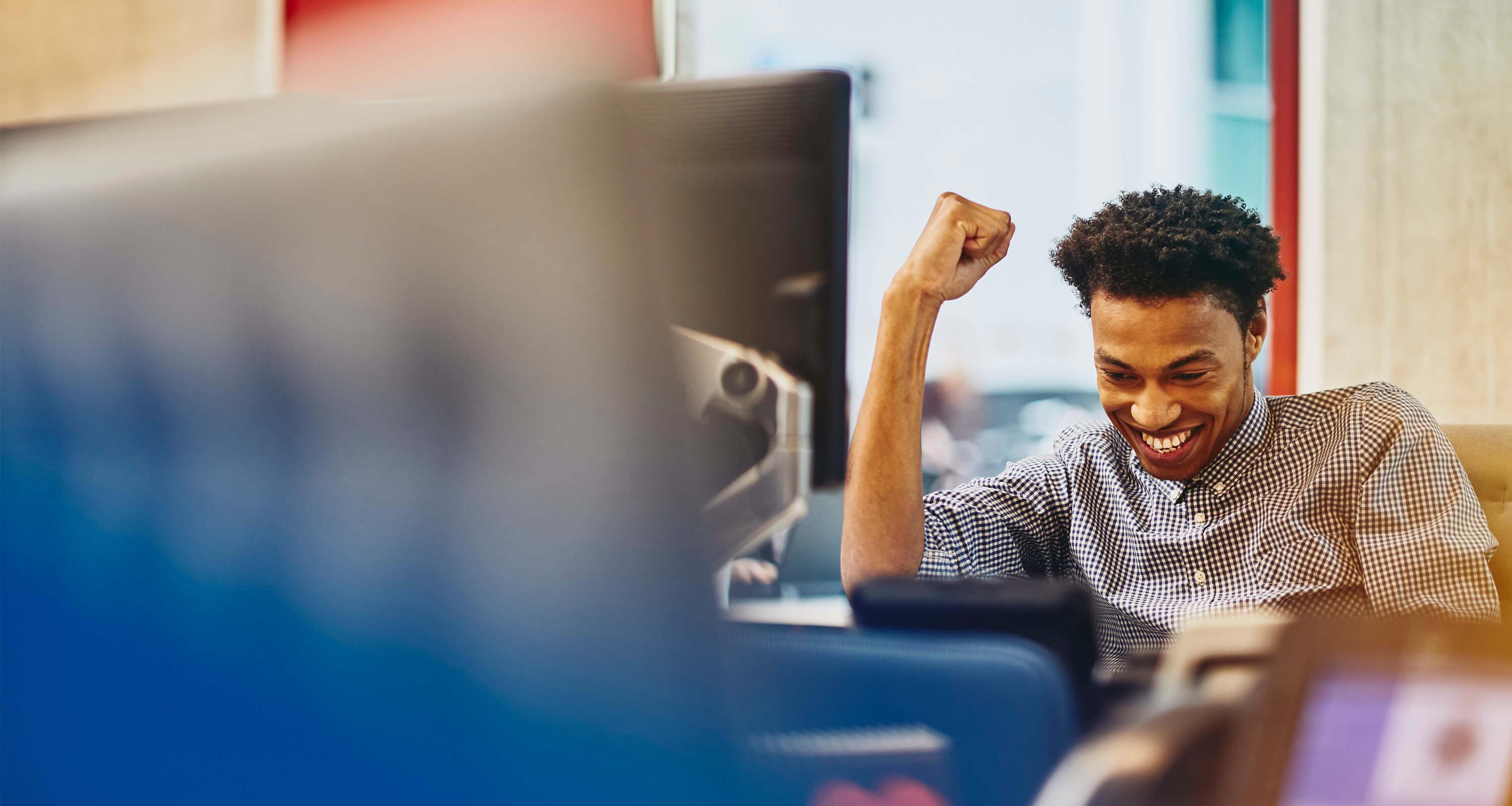 A photo of a man in his workplace expressing success