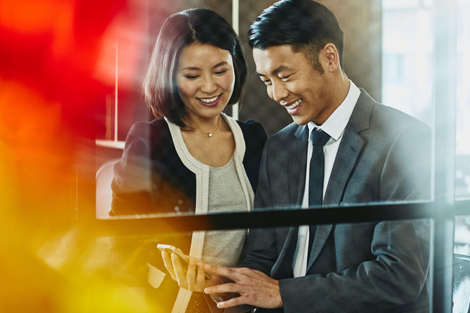 Man and woman in the office looking at a phone