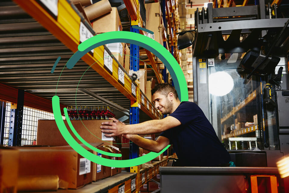 an image of a man in elevator between distribution center racks, picking up a box from a shelf