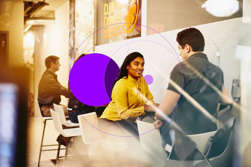 woman and man speaking in the office with purple illustration