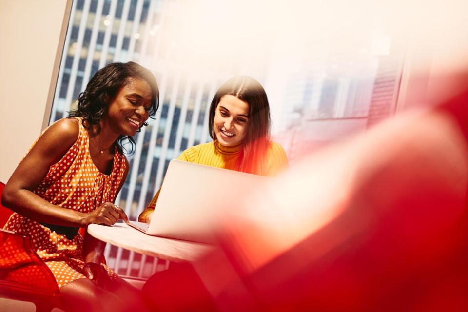 image of two women smiling and working