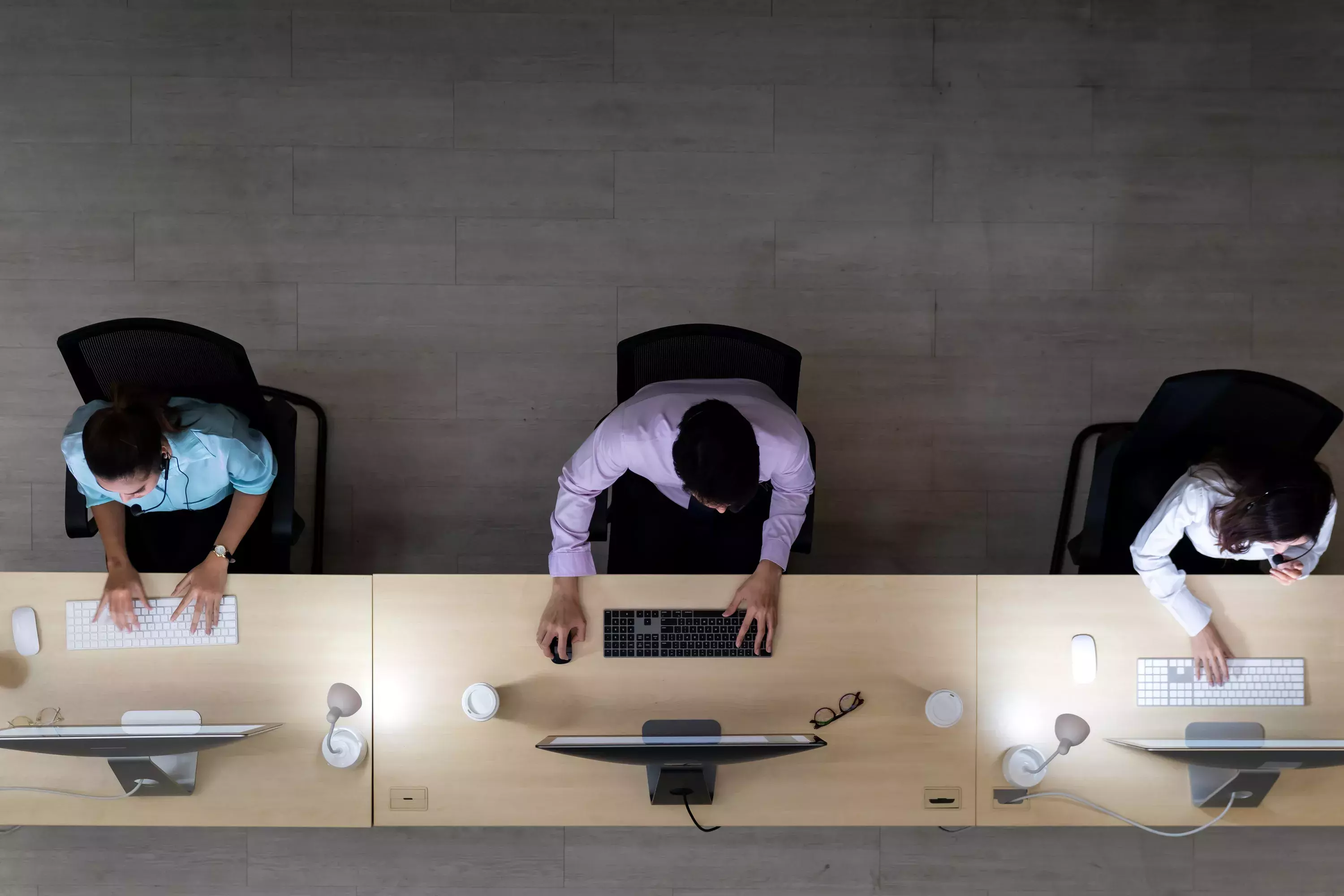 Top view of call centre operator team with headsets working in a call centre customer service and technical support.
