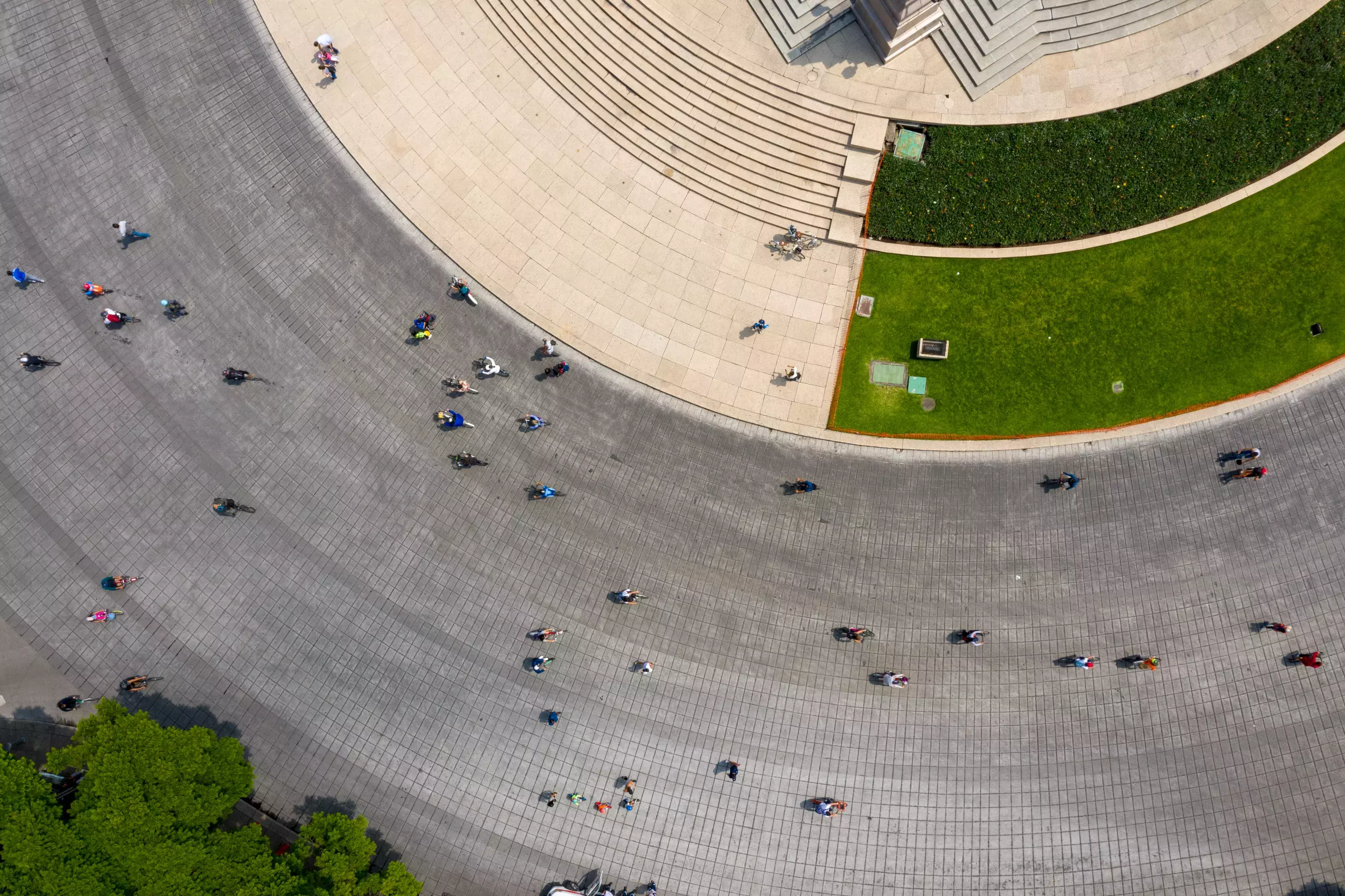 Aerial view of people walking around curved street.