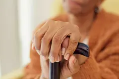 an image of an old woman holding a cane, camera zoomed in on her hands