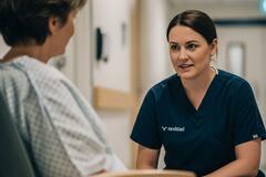a female nurse in a hospital having a conversation with a patient