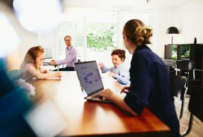 Woman working from home with her family in the background