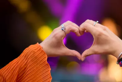 Close up of person making heart shaped hand gesture 