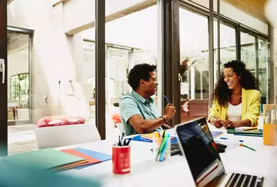 male and female having a laugh during a meeting in a meeting room.
