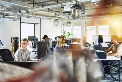 Group of people working behind their computers at their cubicles at the office. Focused.