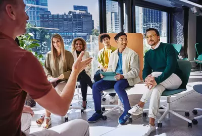Group of people having a meeting, in a room with glass windows