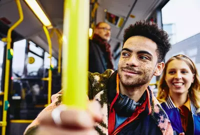Womale and boy smiling, sitting in a bus.
