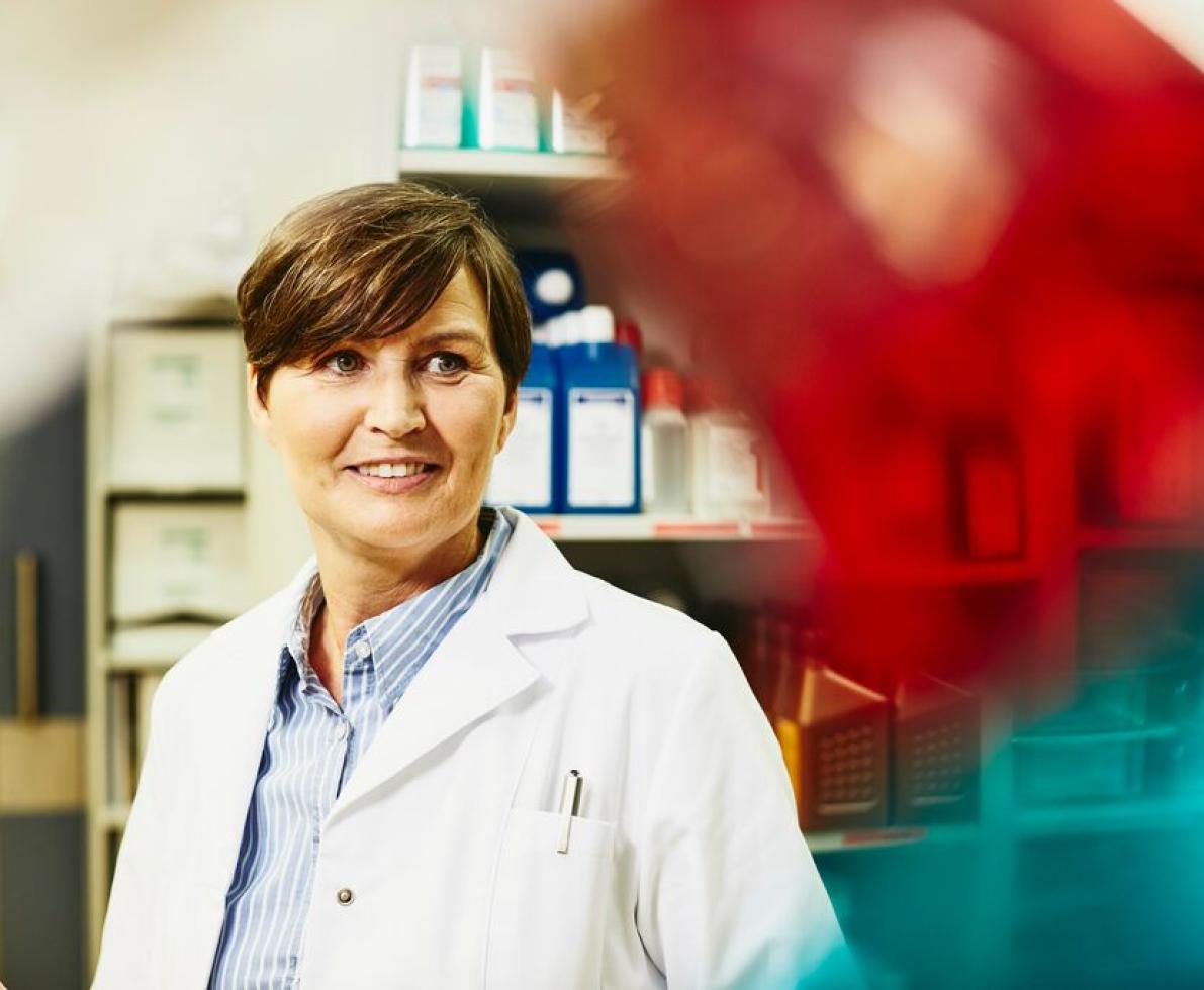 A photo of a woman wearing a laboratory coat working as a conservation scientist