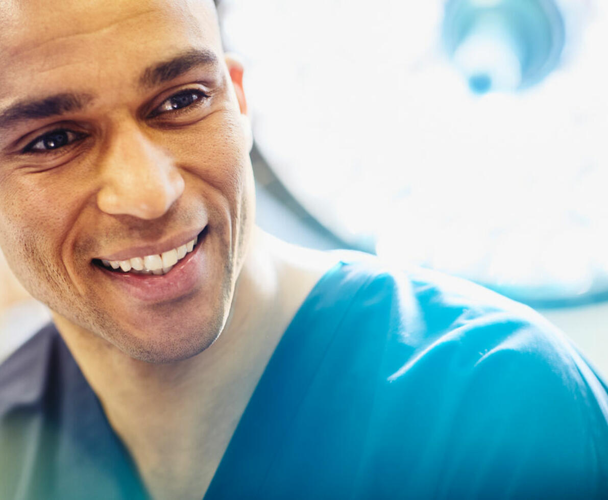 image of a male nurse smiling with a bright light overhead