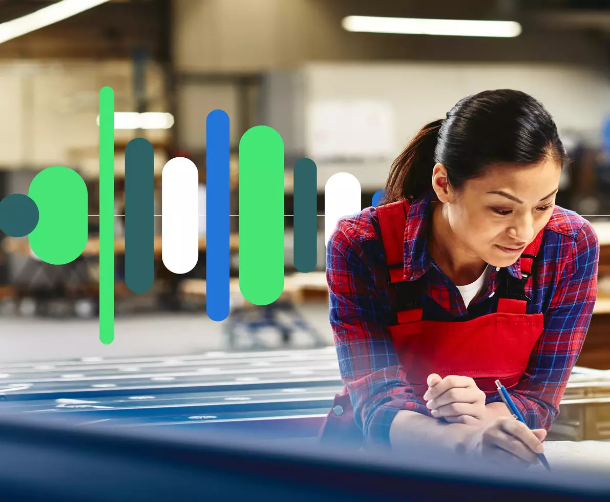 an image of a woman wearing a red overall writing on a paper in a production site/factory